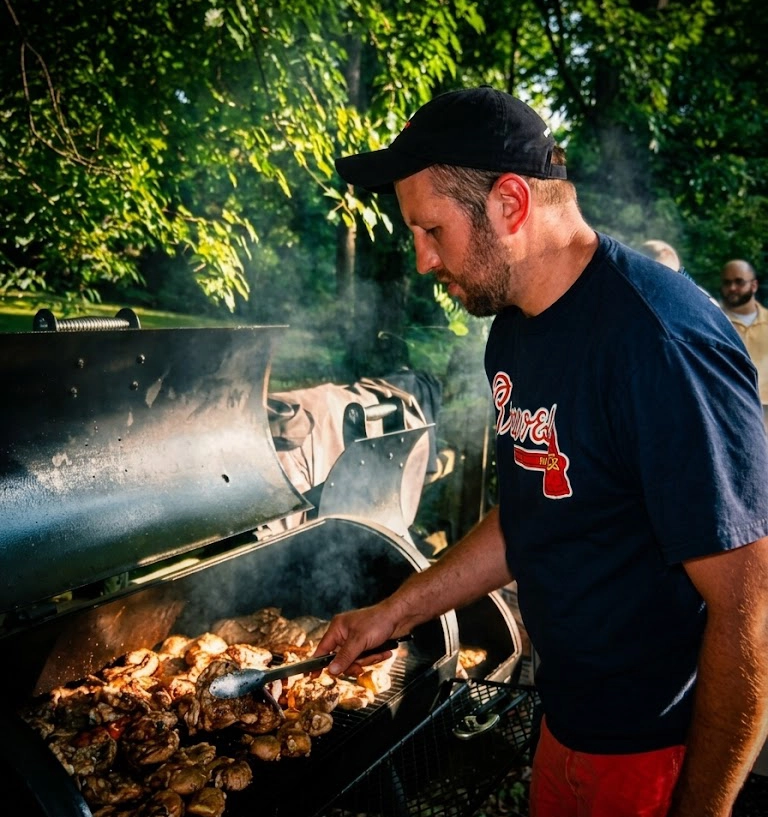 Grilling meat at Battleground Butcher Bar outdoor event for barbecue enthusiasts.